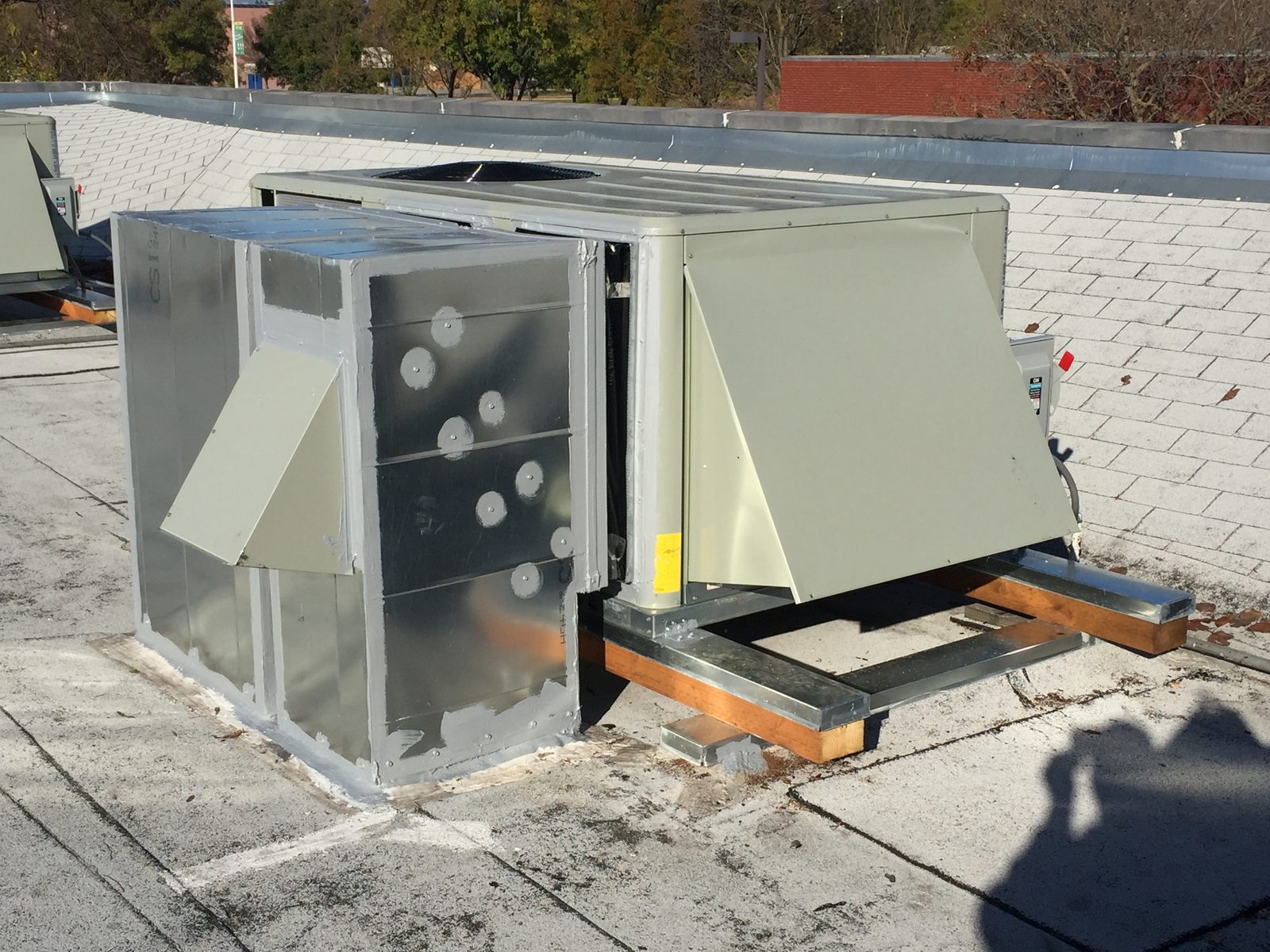 Shop fabricated plenum with a relief hood on the return that vents excess pressure when the unit is economizing