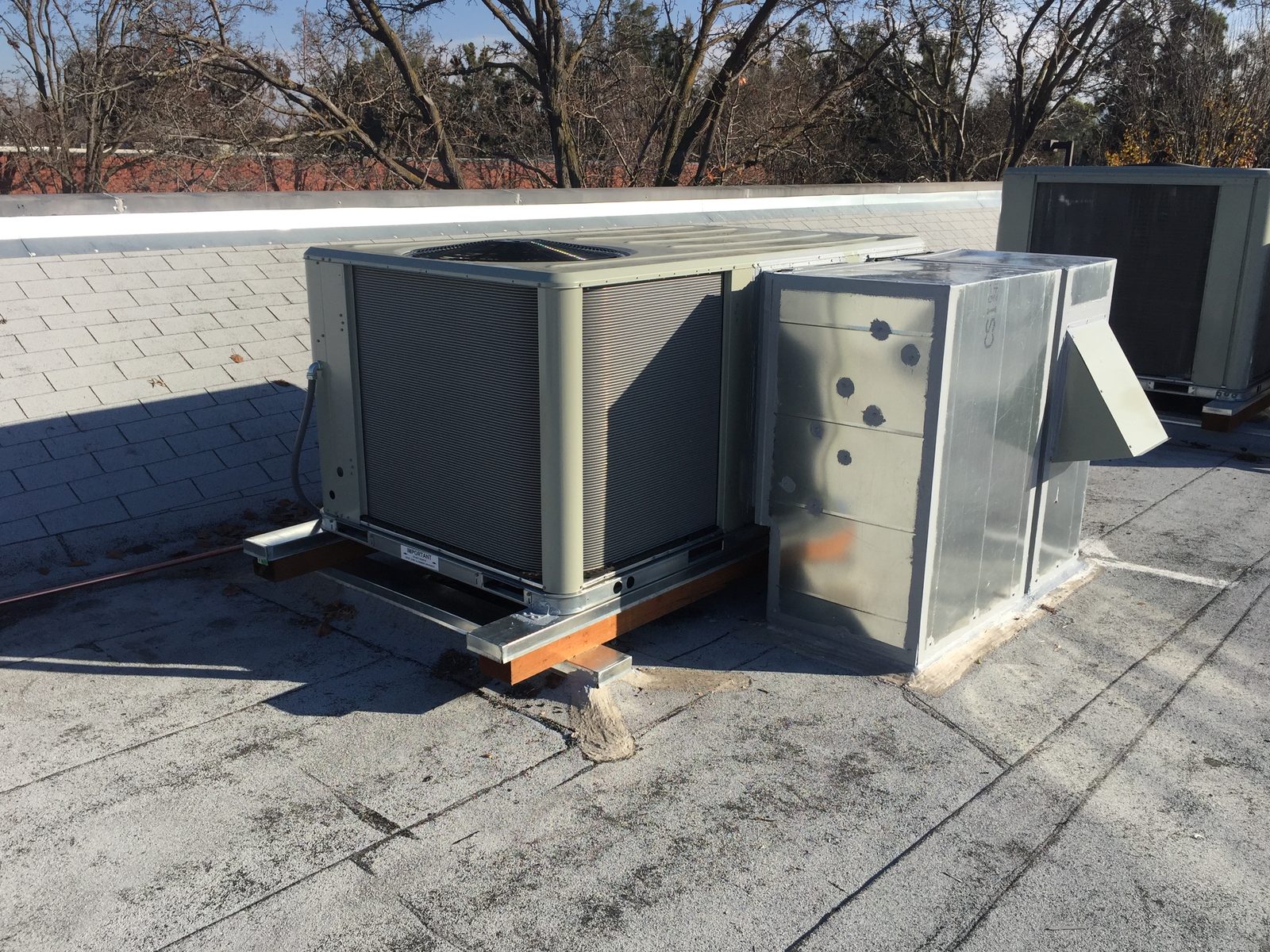 Packaged rooftop unit with a fabricated plenum alongside it